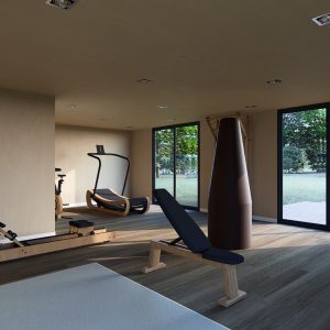 Salle de sport moderne et lumineuse aménagée dans un module en bois, équipée de matériel design et écologique, avec vue sur un jardin verdoyant grâce à de grandes baies vitrées.